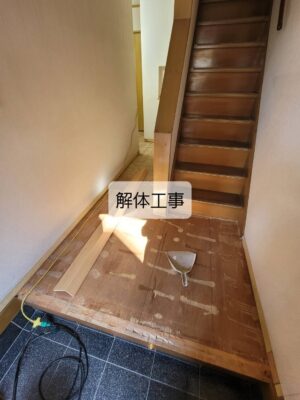 玄関から廊下にかけて既存フローリングを解体している様子
