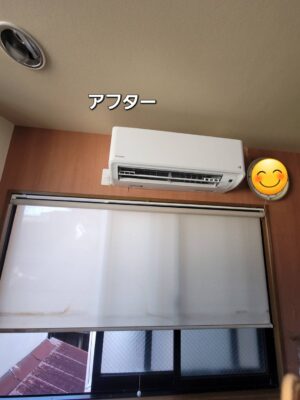 ロールスクリーンのある窓の上に設置された交換後のエアコン